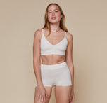 Model wearing the Cloud Cotton Triangle Bralette and matching Highwaist Cloud Cotton Boyshort in the color Heathered Oatmeal. sizing: Erin wears size Small
