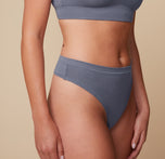 Close-up shot of Megan’s midsection, wearing the Cloud Cotton Highwaist Thong in Slate. The image focuses on the fit and waistband detail.