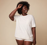 Model Akesha wearing the Cloud Cotton Tee in Heathered Oatmeal, with a relaxed and comfortable fit. The soft fabric and casual style are highlighted in this front-facing pose.
