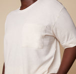 Close-up of model Akesha in the Cloud Cotton Tee in Heathered Oatmeal, showing the soft fabric and chest pocket detail. The image highlights the casual and comfortable design.