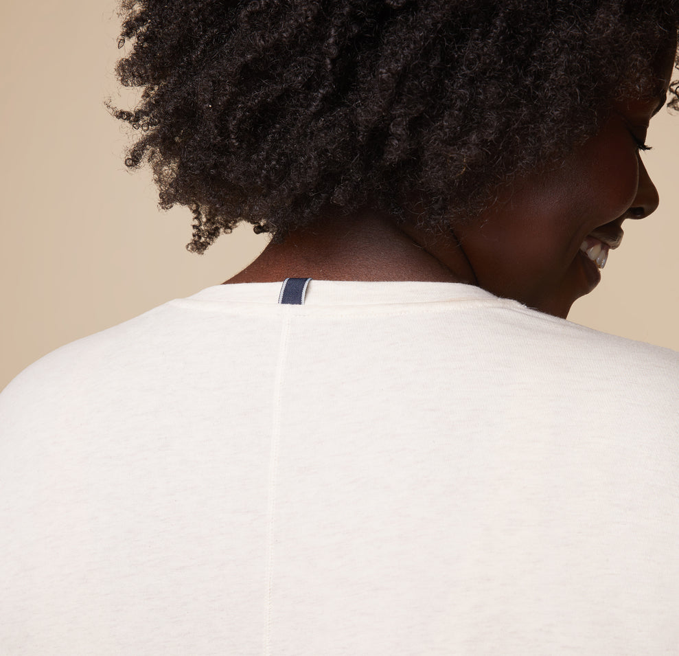 Back close-up of model Akesha wearing the Cloud Cotton Tee in Heathered Oatmeal, focusing on the neckline and seam detail.