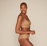 Woman wearing the Bliss Scoop Bralette in the color Tan sizing: Danah wears size Small