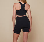 Back view of model wearing the Flex Racerback Sport Tank with the matching Flex High Rise Bike Shorts in black.