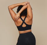 Back view of model wearing the Flex Crossback Convertible Sports Bra and matching Flex High Rise Leggings in Black. Convertible bra straps are shown in a racerback position.