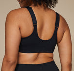 Model wearing the Flex Crossback Convertible Sports Bra and matching Flex High Rise Leggings in Black. Close up of the back of the bra.