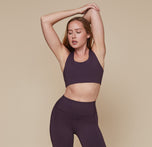Model wearing the Flex Convertible Sports Bra and matching Flex High Rise Leggings in the color Mulberry sizing:Erin wears size Small