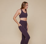 Model wearing the Flex Convertible Sports Bra and matching Flex High Rise Leggings in the color Mulberry