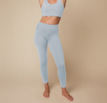 Megan standing with her arms raised showcasing the Flex Convertible Sports Bra and Flex High Rise Legging in Thistle.