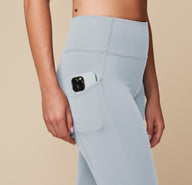 Close-up of the Flex High Rise Legging in Thistle, highlighting the side pocket detail holding an iPhone.