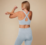Megan showing the back of the Flex Convertible Sports Bra in Thistle with the straps adjusted to cross in the back.