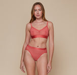 Model wearing the Luxe Mesh Bralette in the color Coral with the matching Luxe Mesh Highwaist Brief. sizing:Erin wears size Small
