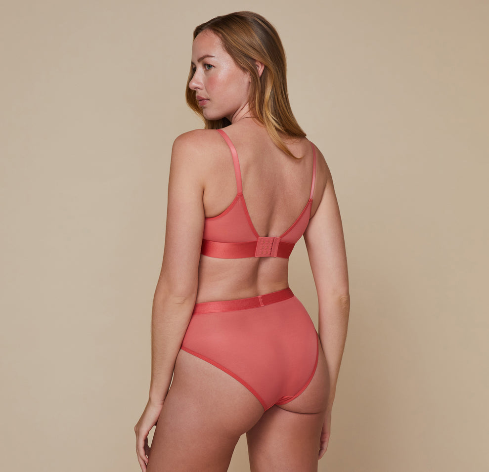Back view of model wearing the Luxe Mesh Bralette in the color Coral with the matching Luxe Mesh Highwaist Brief.
