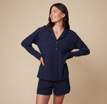 Model Anna wearing the Pima PJ Longsleeve and Pima PJ Shorts in Navy, with the shirt buttoned up. The image highlights the soft fabric and relaxed fit of the loungewear set.
