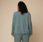 Back view of model Bianca wearing the Pima PJ Longsleeve and Pima PJ Pants in Rainforest. The image highlights the relaxed, loose fit of the soft, flowy fabric.