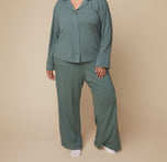 Model Bianca standing in the Pima PJ Pants in Rainforest with a buttoned up Pima Longsleeve, emphasizing the relaxed fit and soft fabric of the set.