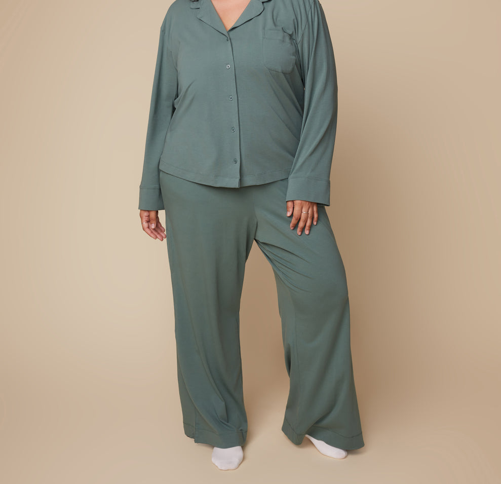 Model Bianca standing in the Pima PJ Pants in Rainforest with a buttoned up Pima Longsleeve, emphasizing the relaxed fit and soft fabric of the set.
