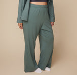 Close-up of model Bianca wearing the Pima PJ Pants in Rainforest, showing the elastic waistband and soft, breathable fabric of the pants in a relaxed pose. sizing: Bianca wears size XL