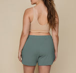 Back view of model Summerlyn wearing Pima PJ Shorts in Rainforest (Size: L). The elastic waistband and relaxed fit are showcased, highlighting the casual and comfortable nature of the shorts.