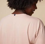 Back view of model Akesha wearing the Pima Tee in Bellini, showcasing the relaxed, casual fit and soft drape of the fabric from behind.