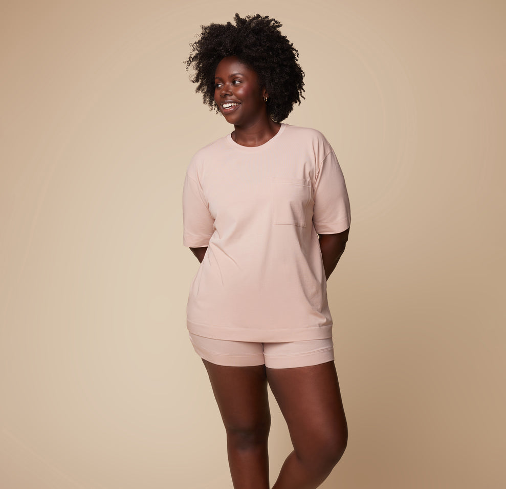 Model Akesha wearing the Pima Tee in Bellini with Pima PJ Shorts, standing in a relaxed pose. The soft, comfortable fabric is highlighted in this full-length shot.