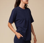 Close-up of model Anna wearing the Pima Tee in Navy, with one hand in her pocket. The soft fabric and relaxed fit are emphasized. sizing: Anna wears size Small