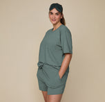 Side view of model Summerlyn wearing the Pima Tee in Rainforest with Pima PJ Shorts, standing casually with hands in pockets. The comfortable and easy fit is highlighted.