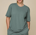 Close-up of model Summerlyn in the Pima Tee and Shorts in Rainforest, with hands in pockets, emphasizing the soft, flowy fabric and relaxed fit. sizing: Summerlyn wears size Large