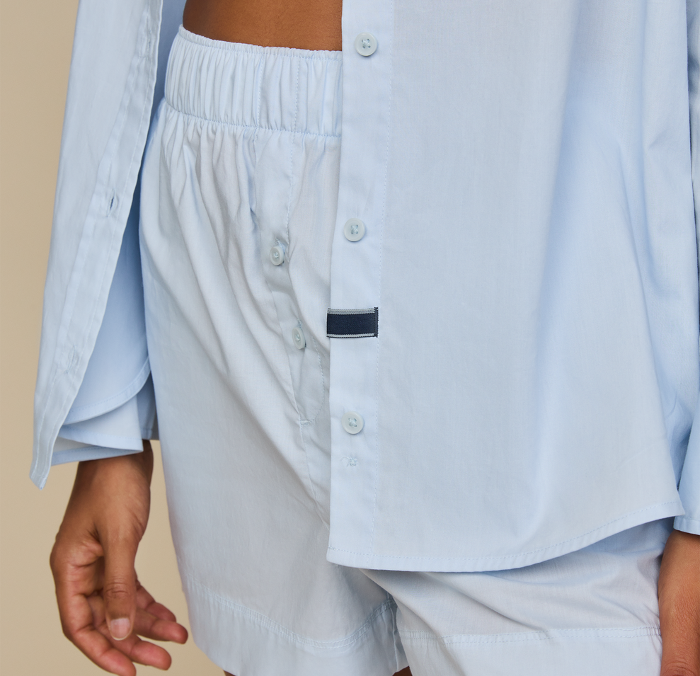 Woman wears Classic Poplin Pajama Shirt in color Ice Blue
