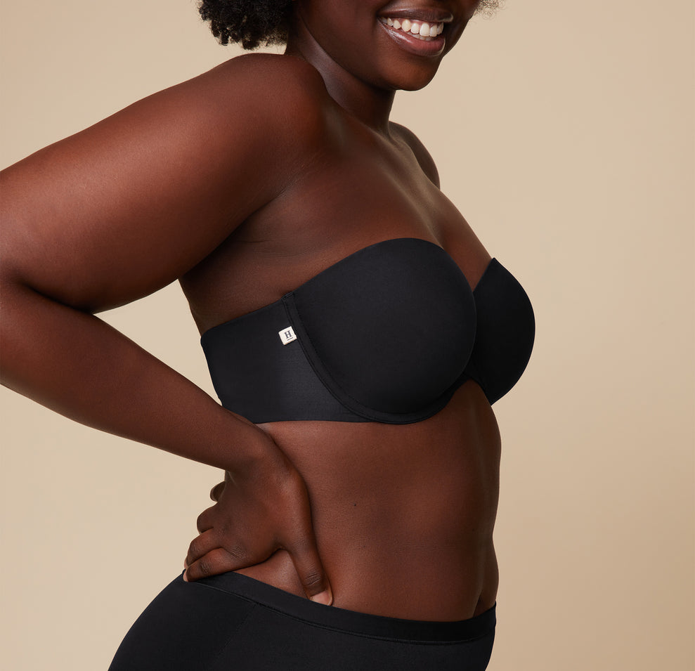 Close-up shot of Akesha’s upper body in the Base Strapless Bra in Black, focusing on the smooth cup design and supportive fit.