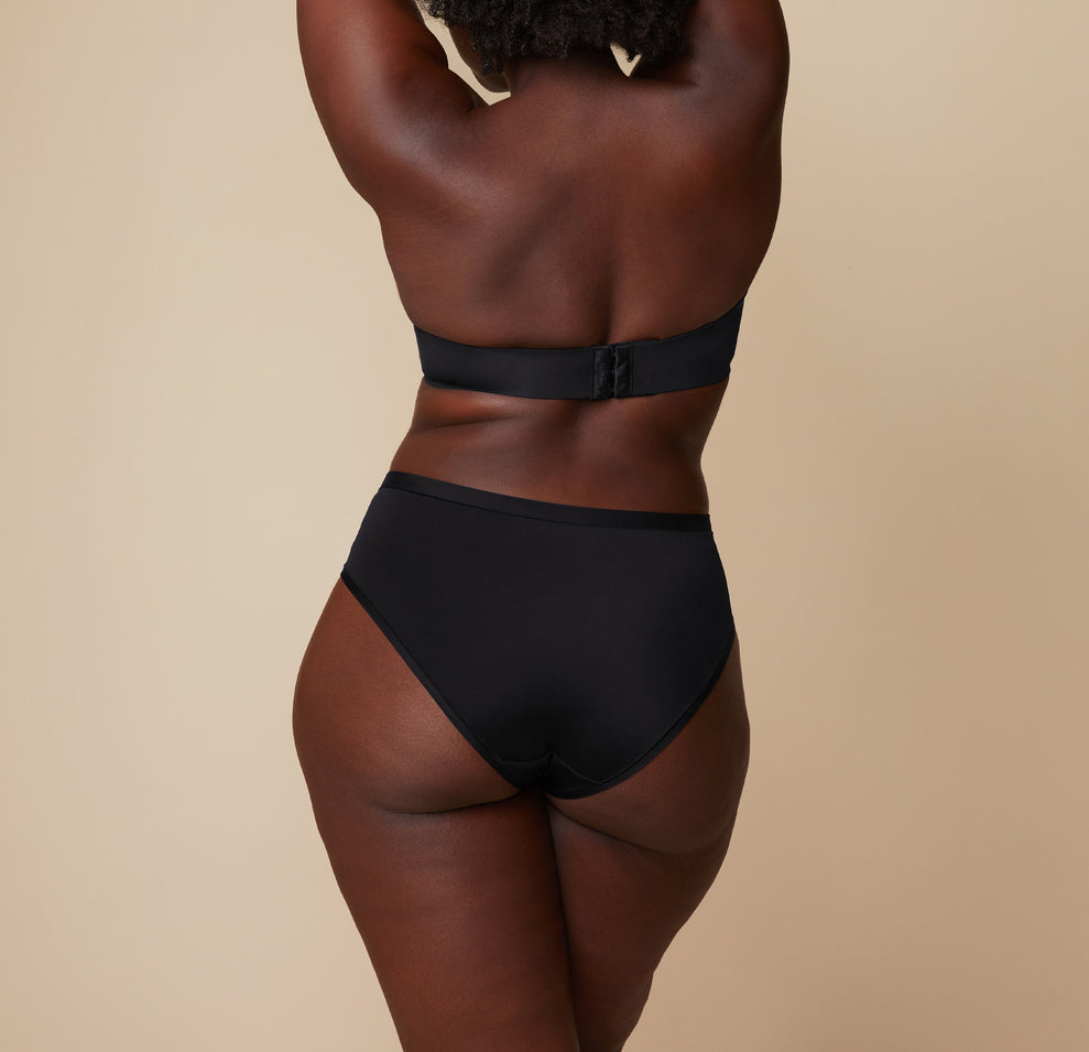 A back view of Akesha in the Bliss Hiphugger, focusing on the coverage and fit of the waistband and the overall silhouette from behind.