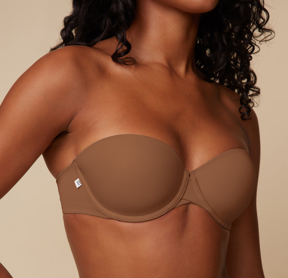 Close-up of model Ally wearing the Base Strapless Bra in Brown, focusing on the contoured cups and seamless edge for an invisible look under clothing.