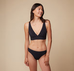 Anna in the Bliss Plunge Adjustable Bralette and Bliss Bikini, looking to her left with a relaxed pose. sizing: Anna wears size Small. Sizes L-4XL have higher center in front for additional support.