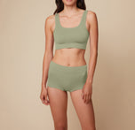Model Anna stands facing forward in the Lounge Boyshort in Sage, with arms relaxed at her sides, highlighting the comfortable fit and ribbed texture. sizing: Anna wears size Small