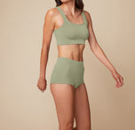 Model Anna stands facing forward in the Lounge Boyshort in Sage, with arms relaxed at her sides, highlighting the high-waist fit and ribbed texture.