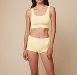 Model Anna standing in the Lounge Rib Boyshort in Sunnyside, showcasing the ribbed fabric for a cozy fit. sizing: Anna wears size Small