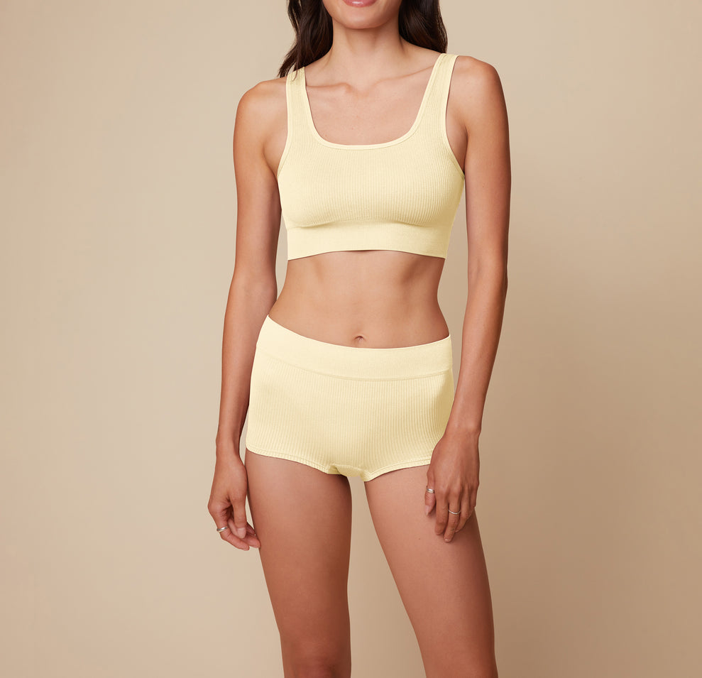Model Anna standing in the Lounge Rib Boyshort in Sunnyside, showcasing the ribbed fabric for a cozy fit. sizing: Anna wears size Small