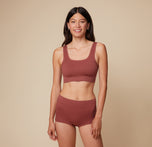 Anna stands facing forward, wearing the Lounge Rib Scoop Bralette and Lounge Rib Boyshort in Clay against a neutral backdrop. sizing: Anna wears size Small