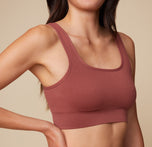 Close-up shot of Anna wearing the Lounge Rib Scoop Bralette in Clay, focusing on the ribbed texture and scoop neckline.