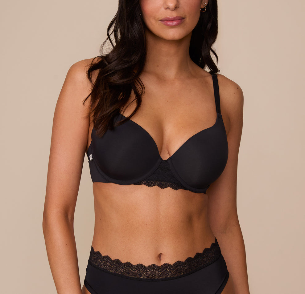 Marcela wearing the Base Lace T-Shirt Bra in Black. The front view showcases the lightly lined underwire cups and scalloped lace trim for a smooth, supportive fit. sizing: Marcela wears size 32D