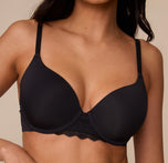 Close-up of Marcela wearing the Base Lace T-Shirt Bra in Black. This shot focuses on the smooth, lightly lined cups and lace center panel for added softness and support.