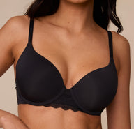 Close-up of Marcela wearing the Base Lace T-Shirt Bra in Black. This shot focuses on the smooth, lightly lined cups and lace center panel for added softness and support.