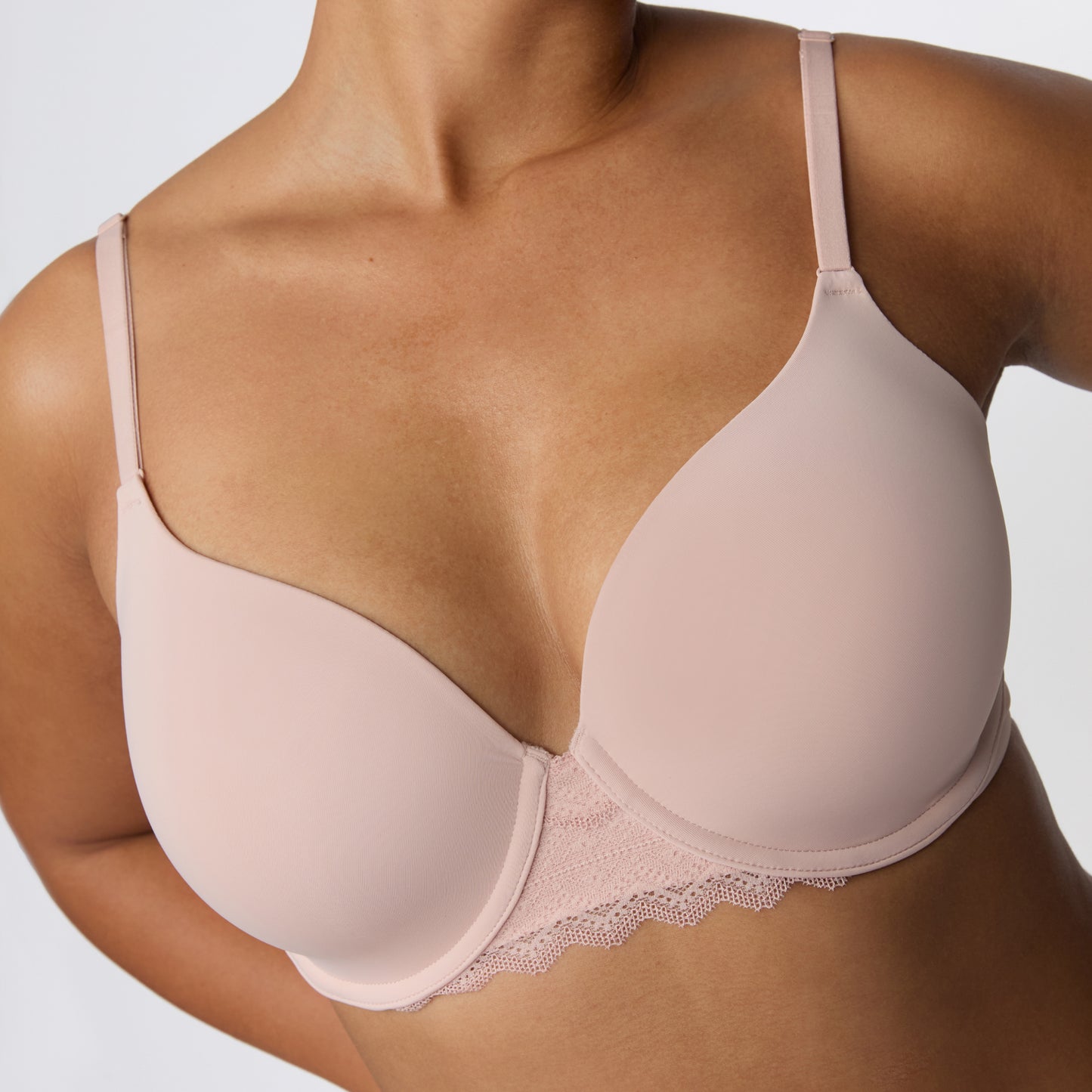 In a studio with a light gray backdrop, India wears the Base Lace Bra in Ember Rose, highlighting the lightly lined cups, center gore, and lace trim along the band.