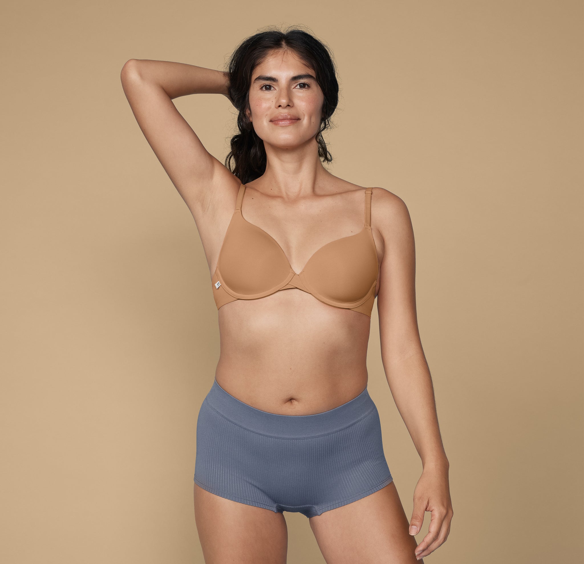 Human hand holding pink bra - Wild About Tan