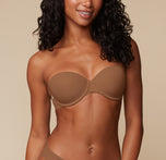 Close-up shot of Ally’s upper body in the Base Strapless Bra in Brown, focusing on the smooth cups and supportive band. sizing: Ally wears size 32C