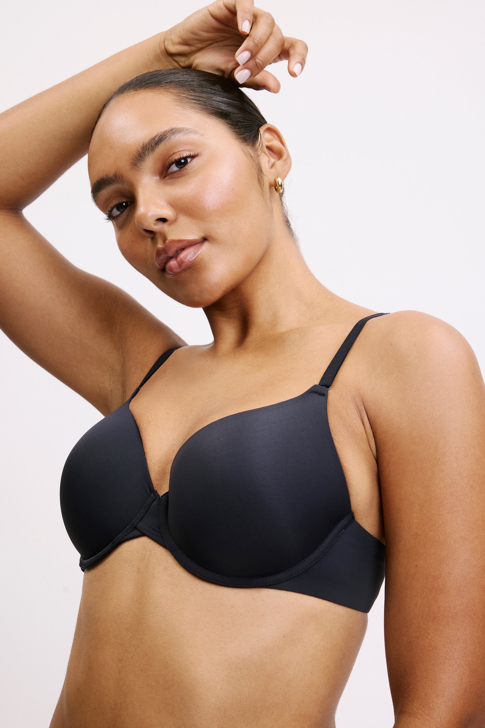 Against a light gray studio backdrop, Amber wears the Base T-Shirt Bra in Black. The lightly lined, full-coverage underwire cups create a smooth shape, finished with thin front-adjusting straps and Harper Wilde’s signature silky-soft microfiber fabric.