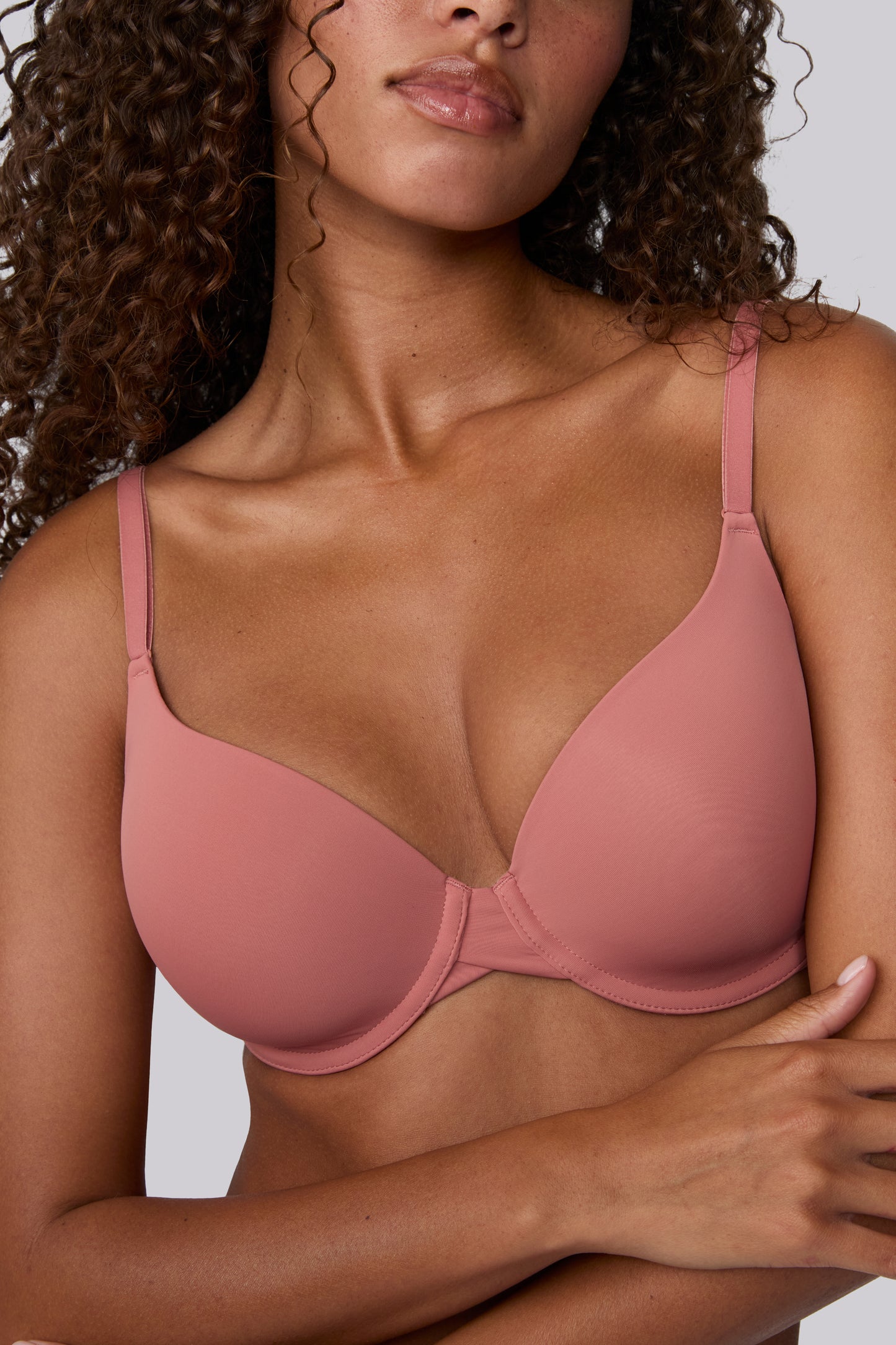 In a studio with a light gray backdrop, Courtney wears the Base T-Shirt Bra in Cinnamon, showing the lightly lined underwire cups, smooth microfiber fabric, and front-adjusting straps. sizing: Courtney wears size 32D
