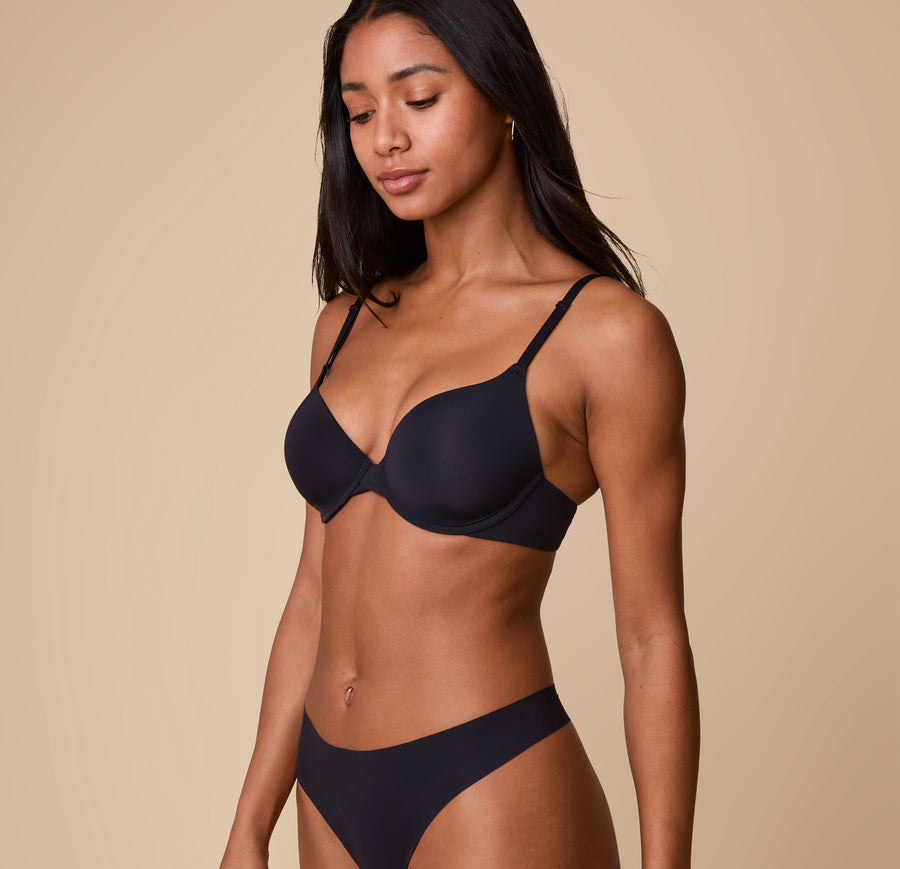 Ally poses in a three-quarter angle wearing the Base T-Shirt Bra in Black, highlighting the contoured fit and comfortable coverage.