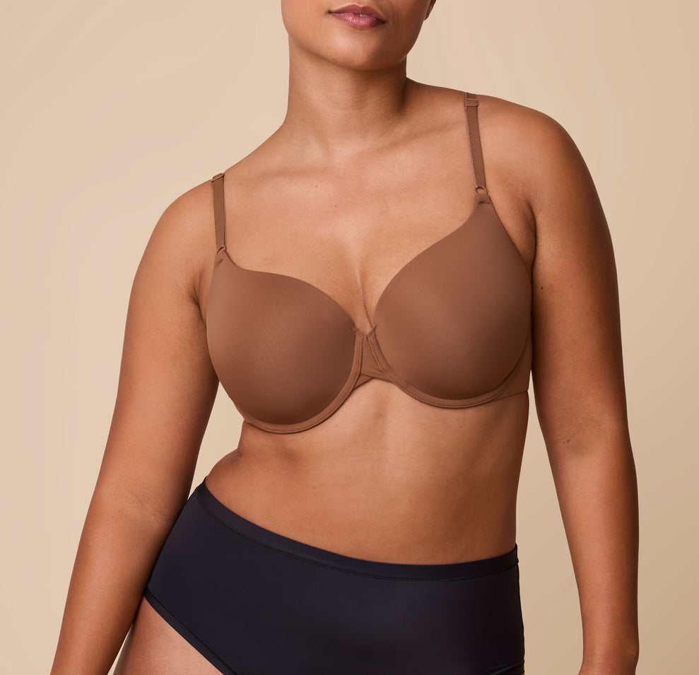 India models the Base T-Shirt Bra in Brown, displaying a front view of the bra’s smooth design with lightly padded cups and adjustable straps. sizing: India wears size 36D