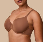 A close-up of India modeling the Base T-Shirt Bra in Brown, focusing on the smooth, ultra soft fabric and supportive underwire structure.