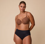 Full-body image of India wearing the Base T-Shirt Bra in Brown, showcasing the bra’s front adjustable straps and supportive fit.